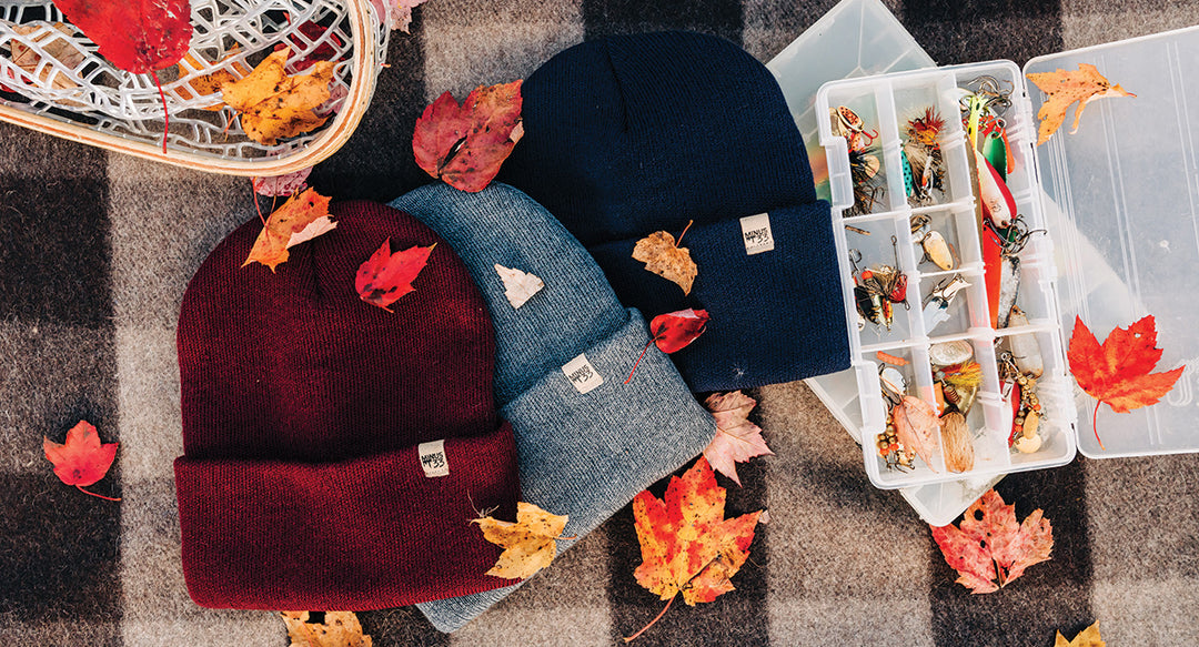 everyday knit beanies with leaves on top of a blanket